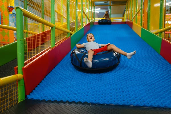 小さな男の子がチューブに乗って エンターテイメントセンターの遊び場 屋内プレイエリア プレイルーム — ストック写真
