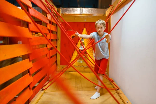小男孩在绳子迷宫里玩耍 娱乐中心的游乐场 室内游戏区 游戏室 — 图库照片