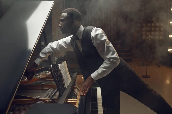 Jogador Africano Afinando Piano Cauda Palco Com Holofotes Fundo — Fotografia de Stock