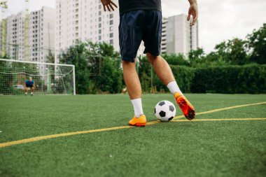 Erkek futbolcu sahada topla çalışıyor. Açık stadyumdaki futbolcu, maçtan önce antrenman, futbol antrenmanı.