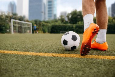 Erkek futbolcu sahada topla çalışıyor. Açık stadyumdaki futbolcu, maçtan önce antrenman, futbol antrenmanı.