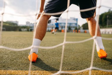Erkek futbol kalecisi kapının arkasında dikiz aynasından duruyor. Açık stadyumdaki futbolcu, maçtan önce antrenman, futbol antrenmanı.