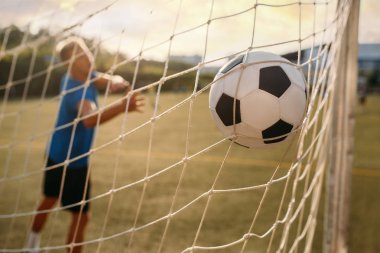 Erkek futbol kalecisi topu kaçırdı ve gol attı. Açık stadyumdaki futbolcu, maçtan önce antrenman, futbol antrenmanı.