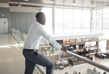 Afrikalı işadamı alışveriş merkezindeki yemek bölümüne bakıyor.