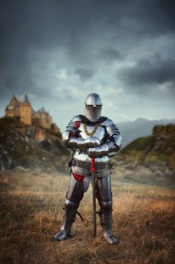 Medieval knight in armor and helmet against castle. Armored ancient warrior in armour in the field clipart