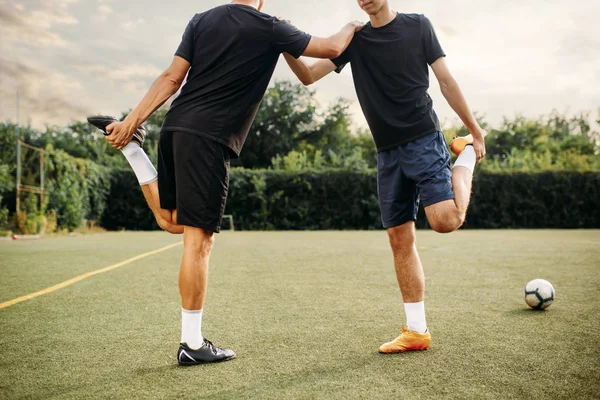 Δύο Ποδοσφαιριστές Κάνουν Διατάσεις Στο Γήπεδο Ποδόσφαιρο Προπόνηση Υπαίθριο Στάδιο — Φωτογραφία Αρχείου