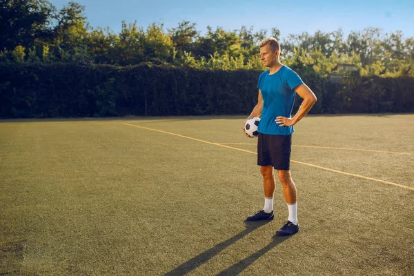 Top sahada duran erkek futbolcu. Açık stadyumdaki futbolcu, maçtan önce antrenman, futbol antrenmanı.
