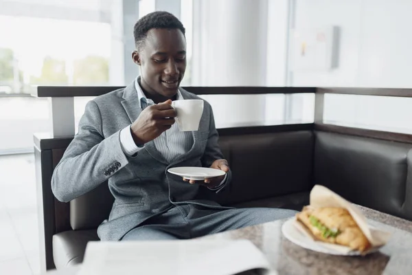 オフィスカフェで昼食をとる若いアフリカ人ビジネスマン — ストック写真