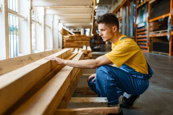 Male builder choosing repair materials in hardware store. Customer look at the goods in diy shop