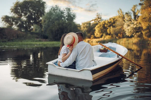 夏の日に湖でボートでキスをするカップルが大好きです ロマンチックなデートボート旅行男と女が川沿いを歩く — ストック写真