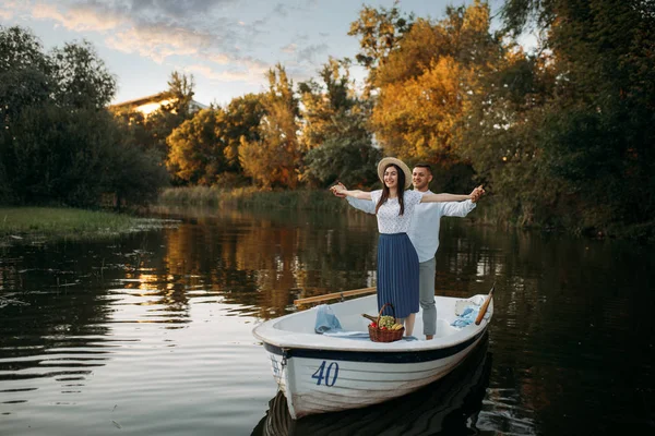 夏日日落时 这对恋人站在平静湖上的小船上 浪漫的相遇 划船旅行 男人和女人沿着河边散步 — 图库照片