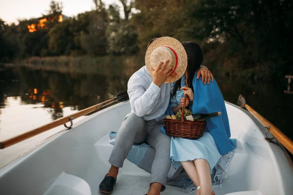 日没時に静かな湖のボートでキスをするカップルが大好きです ロマンチックな出会い ボート旅行 男と女が川に沿って歩く — ストック写真