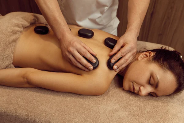Male Masseur Puts Stones Back Slim Woman Towel Professional Massage — Stock Photo, Image