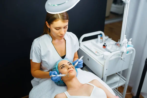 Kosmetyk Wygładza Twarz Pacjentki Wstrzyknięciach Botoksu Zabieg Odmładzania Salonie Kosmetycznym — Zdjęcie stockowe