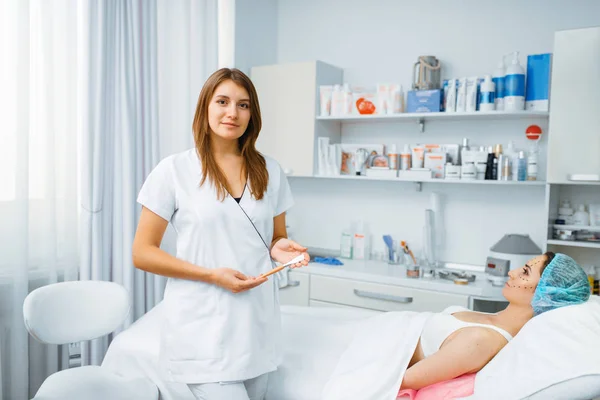 治療テーブル上の女性患者の近くの化粧品 ボックス注射の準備 美容室での若返りの手順 医師と女性 しわや老化に対する美容整形 — ストック写真