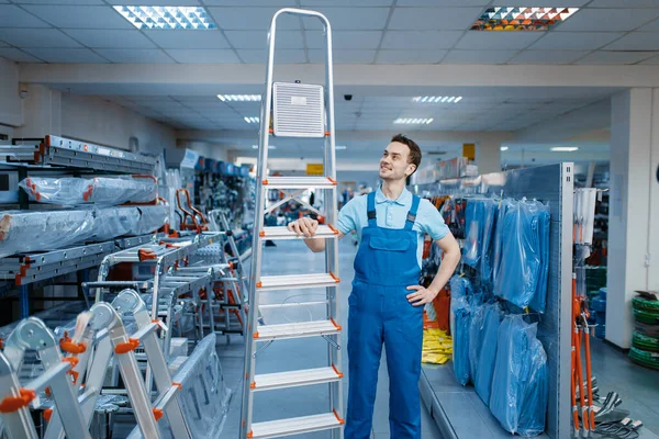 Trabalhador Masculino Uniforme Detém Novos Escadotes Alumínio Loja Ferramentas Departamento — Fotografia de Stock