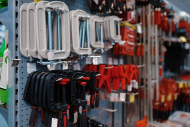 Alet dükkanındaki askılarda mengene ve klempler, hiç kimse. Hırdavatçıdaki ekipman seçimi, süpermarketteki profesyonel enstrüman