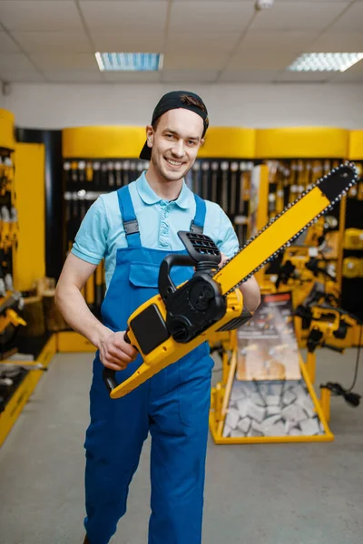 Mannelijke Werknemer Uniform Houdt Kettingzaag Gereedschapswinkel Keuze Van Professionele Apparatuur — Stockfoto