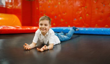 Eğlence merkezinde trambolinde kayganlaştırıcı küçük çocuk. Tatildeki kızlar, çocukluk mutluluğu, çocuk parkındaki mutlu çocuklar.