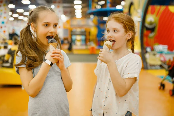 两个女孩在娱乐中心吃冰淇淋 孩子们在度假 童年时代快乐 快乐的孩子们在操场上 — 图库照片