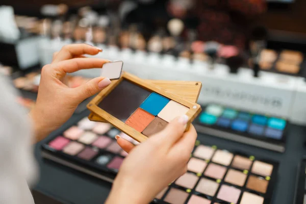 Mujer Sostiene Sombras Estante Tienda Cosméticos Comprador Escaparate Salón Belleza — Foto de Stock