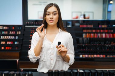 Kozmetik mağazasında güzel bir kadın. Lüks güzellik salonundaki mağaza alıcısı, moda pazarındaki kadın müşteri.