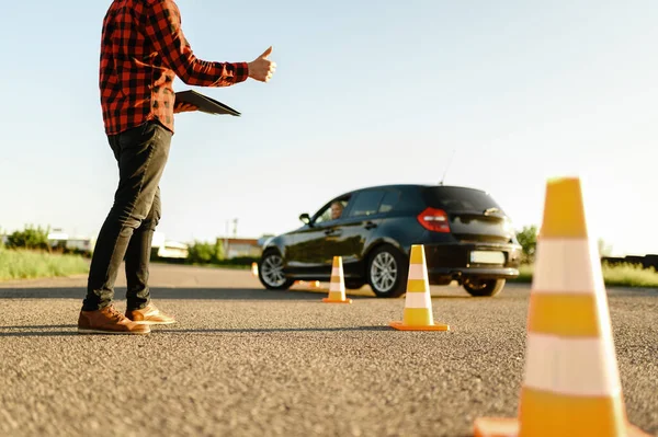 Instruktör hjälper eleven att köra mellan kottar — Stockfoto