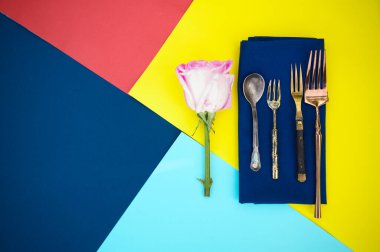 Masa seti, çiçek ve gümüş takımlar mavi peçeteye yakın çekim, üst manzara, hiç kimse. Ziyafet dekorasyonu, renkli masa örtüsü, masa takımı.