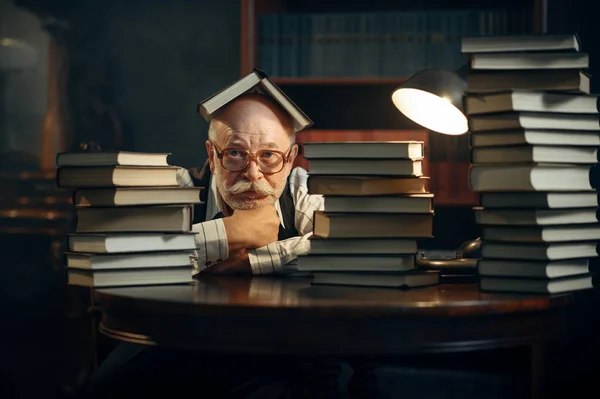 Evde Kitap Yığınıyla Masada Oturan Sevimli Yaşlı Bir Yazar Gözlüklü — Stok fotoğraf