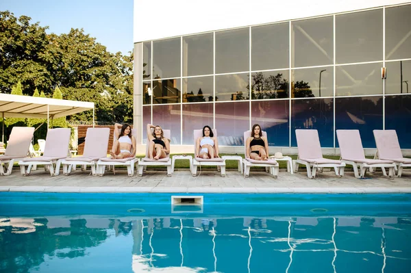 Vier Sexy Frauen Entspannen Auf Sonnenliegen Pool Blick Vom Wasser — Stockfoto