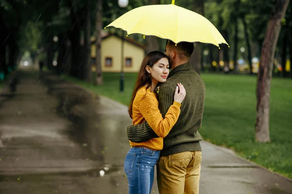 사랑하는 커플이 공원에서 포옹하고 여름비가 남자와 여자는 아래서 낭만적 데이트를 — 스톡 사진