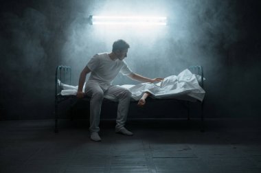 Üzgün psikopat adam yatakta ölü kadına bakıyor, arka planda karanlık oda. Psikedelik kişilik her gece sorun yaşıyor, depresyon ve stres, üzüntü, psikiyatri hastanesi