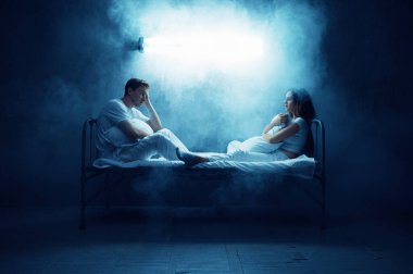 Deli adam ve kadın yatakta, arka planda karanlık bir odada oturuyorlar. Psikedeliklerin her gece sorunları oluyor, depresyon ve stres, üzüntü, psikiyatri hastanesi.