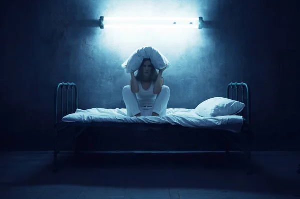 精神错乱的女人 头枕着枕头坐在床上 背景是黑暗的房间 精神病患者 每天晚上都有问题 精神病医院 — 图库照片