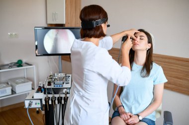 Bayan otolaryngolog ve hasta muayenede. Klinikte burun muayenesi, profesyonel teşhis, doktor. Tıp uzmanı ve kadın hastanede, laringolojist.