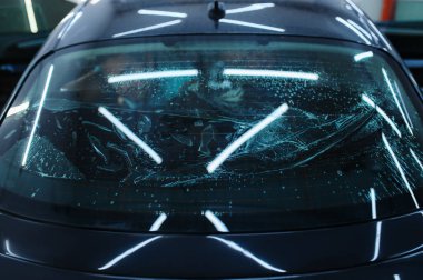 Arabanın arka camında ıslaklık, hiç kimse, araç akort servisi. Vinil boya kurulumu, garajda iş, renkli otomobil camı.