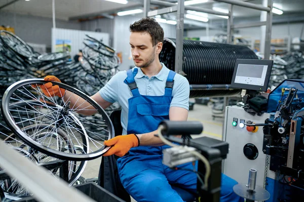 机修工穿着制服 工厂里有自行车轮子 车间中的自行车轮毂和轮毂组装 自行车零件安装 — 图库照片