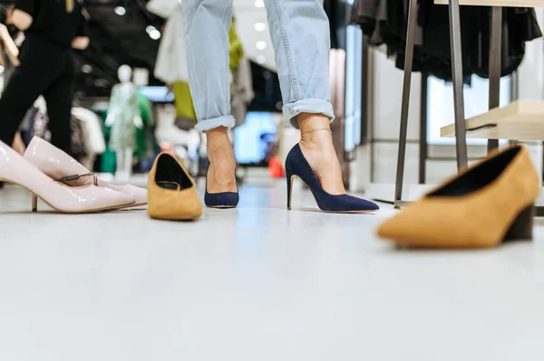 衣料品店で靴を履こうとする若い女性 ファッションブティックでの女性の買い物 ショッピング ブーツを見て買い物 — ストック写真
