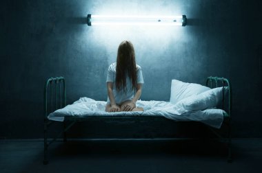Psikopat kadın yatakta çığlık atıyor, uykusuzluk korkusu, arka planda karanlık dumanlı oda. Psikedelik kişilik her gece sorun yaşıyor, depresyon ve stres, üzüntü, psikiyatri hastanesi