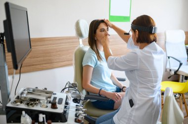 Kadın doktor ve hasta muayenede. Klinikte burun muayenesi, profesyonel teşhis. Tıp uzmanı ve kadın hastanede, laringolojist.