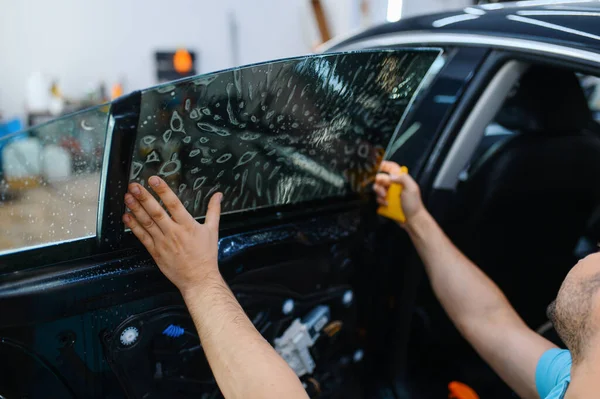 Mężczyzna Pracownik Instaluje Podbarwienia Samochodu Usługi Strojenia Mechanik Stosujący Odcień — Zdjęcie stockowe