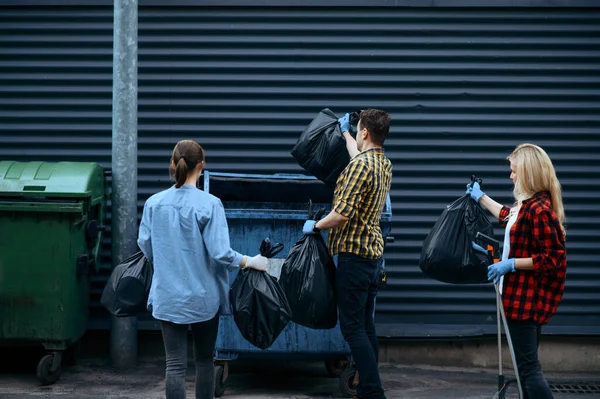 志愿者们在户外把塑料垃圾袋放进罐子里 志愿工作 人们清扫城市街道 生态恢复 垃圾收集和循环利用 生态护理 环境清洁 — 图库照片
