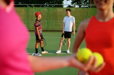 Mixed doubles tennis, players begins the game, outdoor court. Active healthy lifestyle, sport with racket and ball, fitness workout with racquets clipart