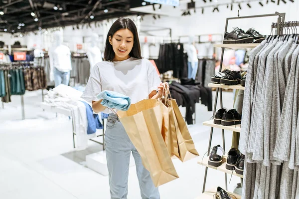 Cheerful Woman Puts Clothes Bag Clothing Store Female Person Shopping — Stock Photo, Image