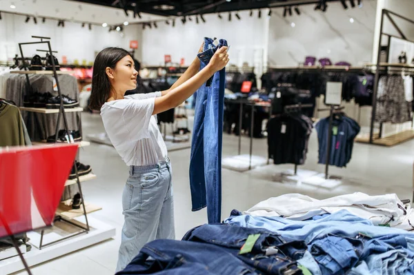 Mulher Alegre Escolhendo Jeans Loja Roupas Pessoa Feminina Fazendo Compras — Fotografia de Stock