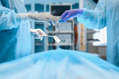 Kadın cerrah ve asistan, operasyon, ameliyathane. Üniformalı doktor, klinik çalışanı, ilaç ve sağlık, hastanede sağlık hizmetleri