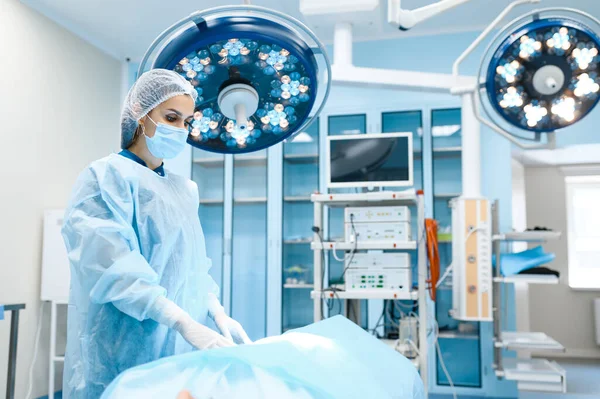 Γυναίκα Χειρουργός Ρόμπα Και Μάσκα Στο Χειρουργείο Λάμπα Στο Παρασκήνιο — Φωτογραφία Αρχείου