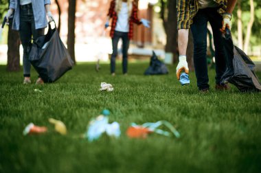 İnsanlar parktaki poşetlerde gönüllü olarak plastik çöp topluyor. Erkek kişi ormanı temizler, ekolojik restorasyon, ekolojik yaşam tarzı, çöp toplama ve geri dönüşüm, ekoloji bakımı, çevre temizliği