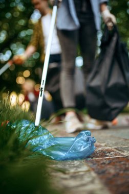 Genç gönüllüler parktaki plastik torbalarda çöp topluyor, gönüllü oluyorlar. İnsanlar ormanı temizliyor, ekolojik restorasyon, ekolojik yaşam tarzı, çöp toplama ve geri dönüşüm, ekoloji bakımı, çevre temizliği