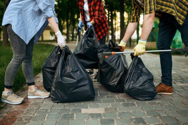 Gönüllüler, gönüllü olarak parkta plastik çöp konteynırlarını tutuyor. Erkek kişi ormanı temizler, ekolojik restorasyon, ekolojik yaşam tarzı, çöp toplama ve geri dönüşüm, ekoloji bakımı, çevre temizliği